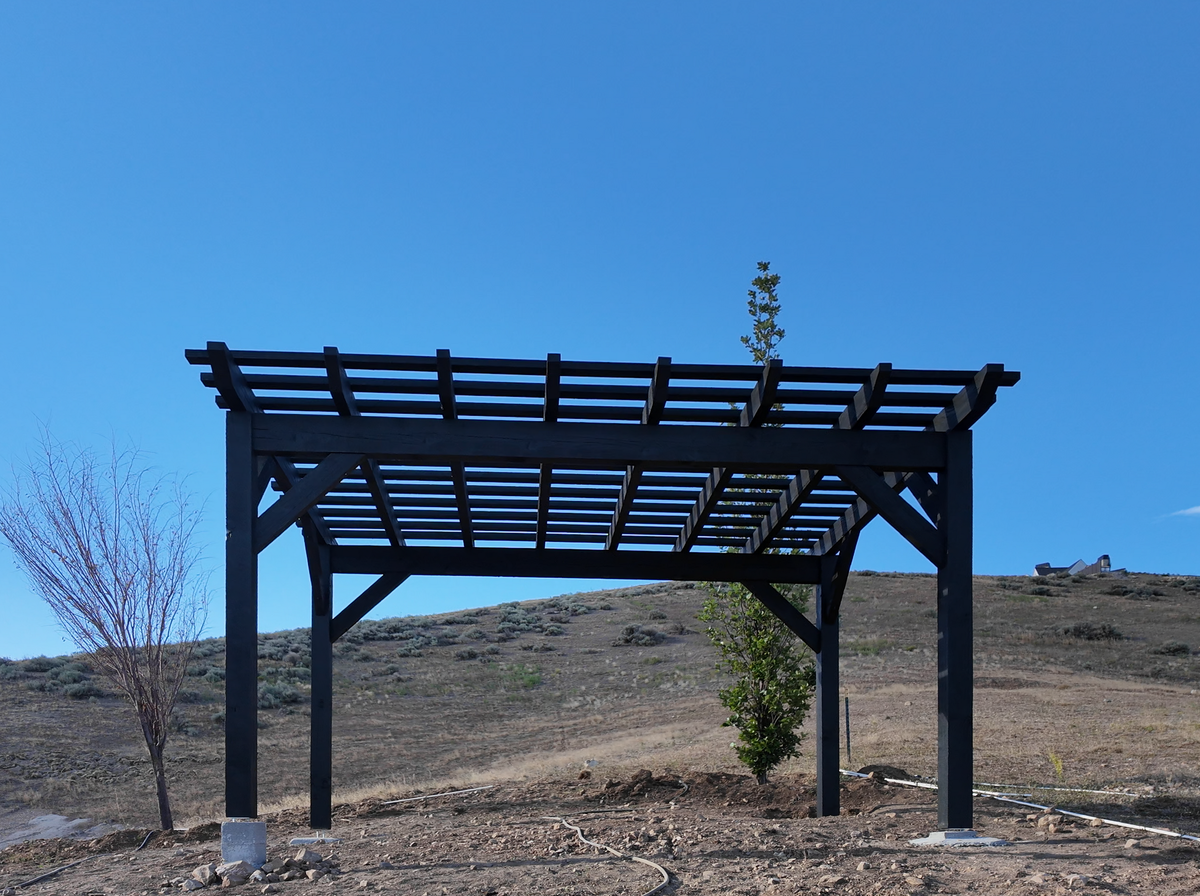 Slate 12×16 pergola with straight knee braces and a lattice top on a hillside lot in Lehi, Utah