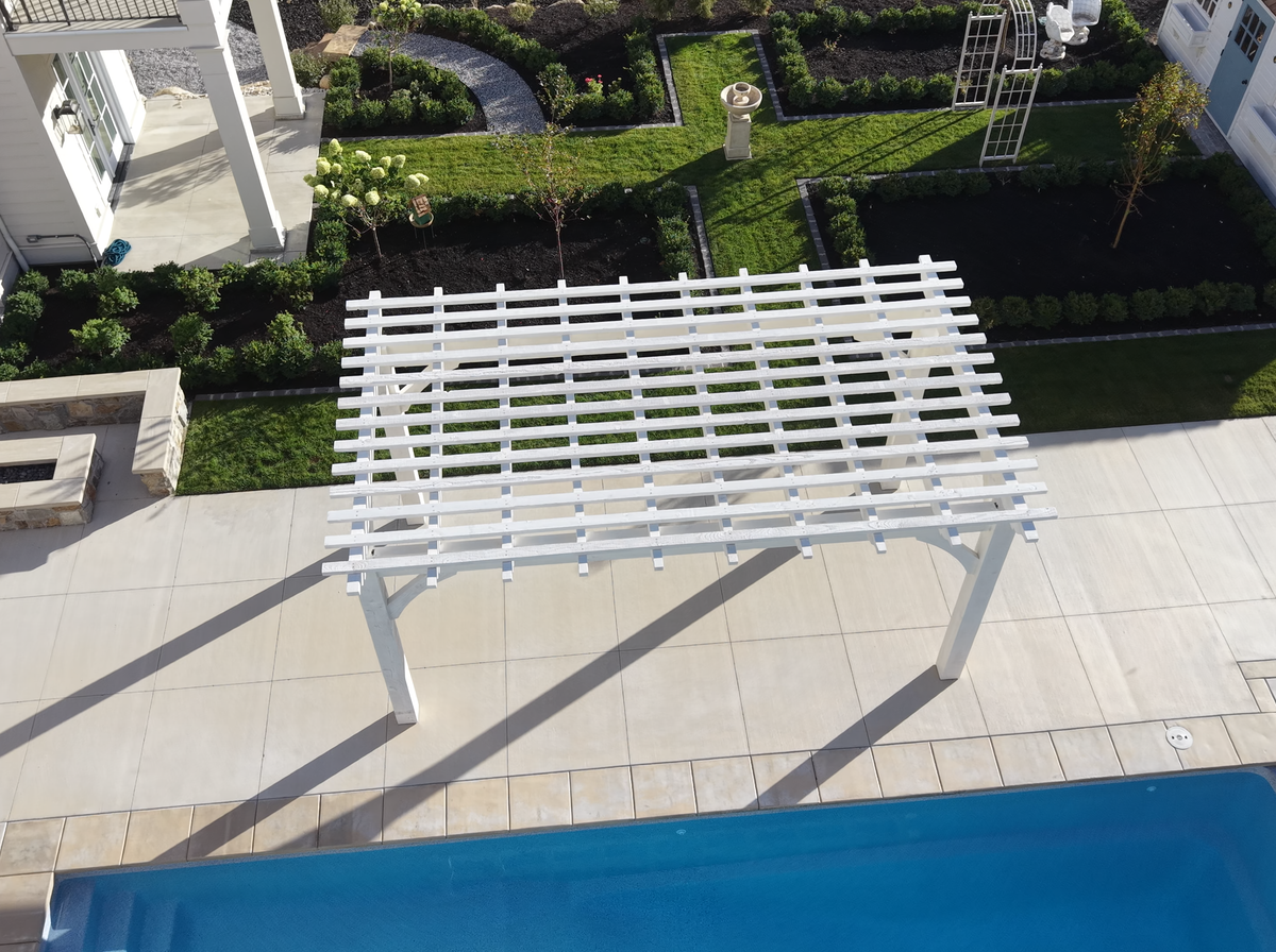 The Pinto White pergola from above, between the pool and the garden beds in Alpine, Utah