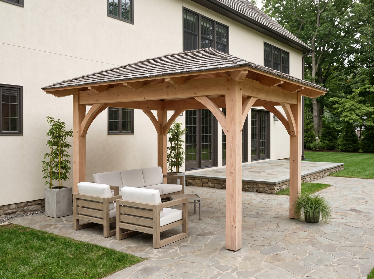 Rustic timber gazebo with a low four-sided hipped roof over a flagstone patio, in natural Douglas fir